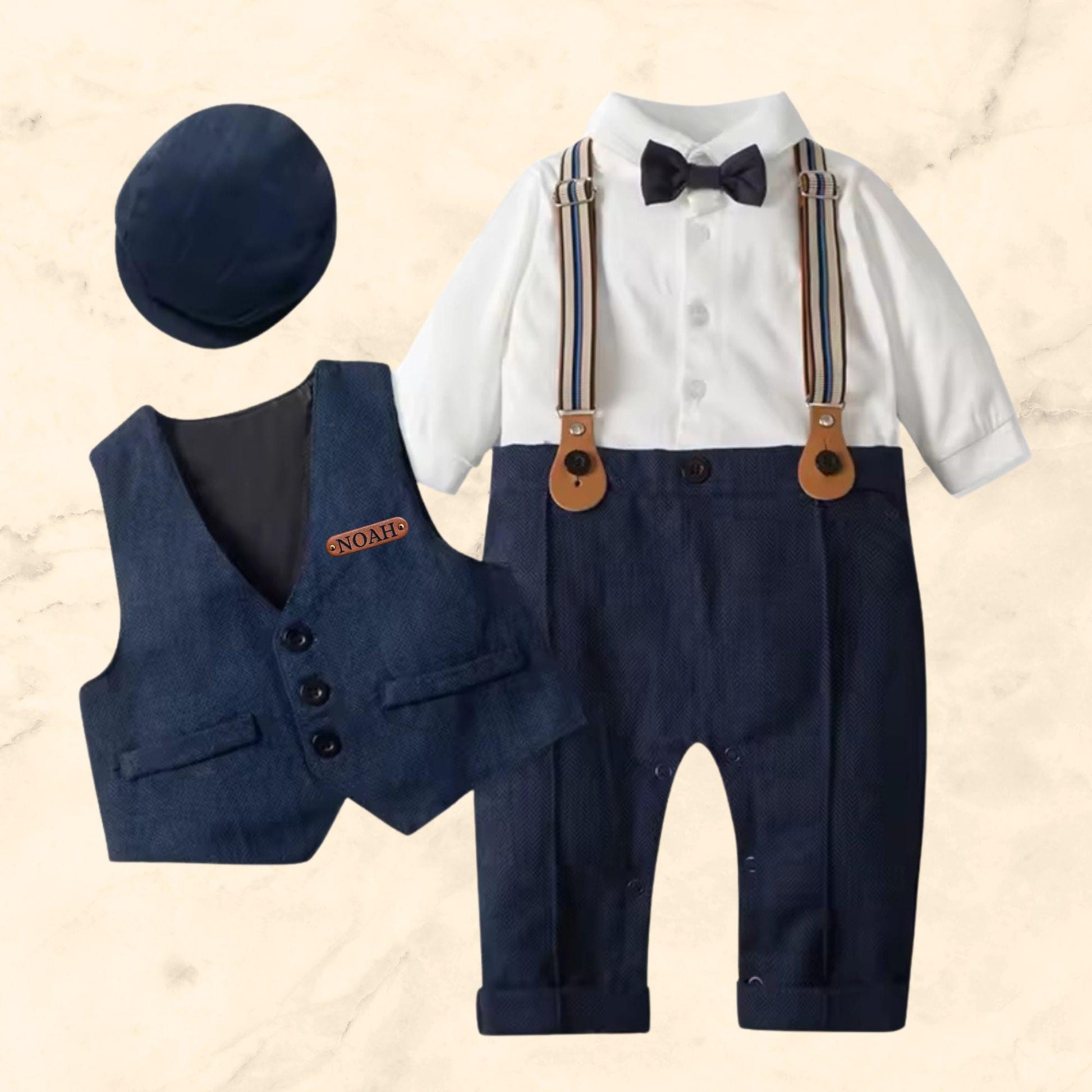 Baby boy dressed in navy blue tuxedo with newsboy hat and bow tie