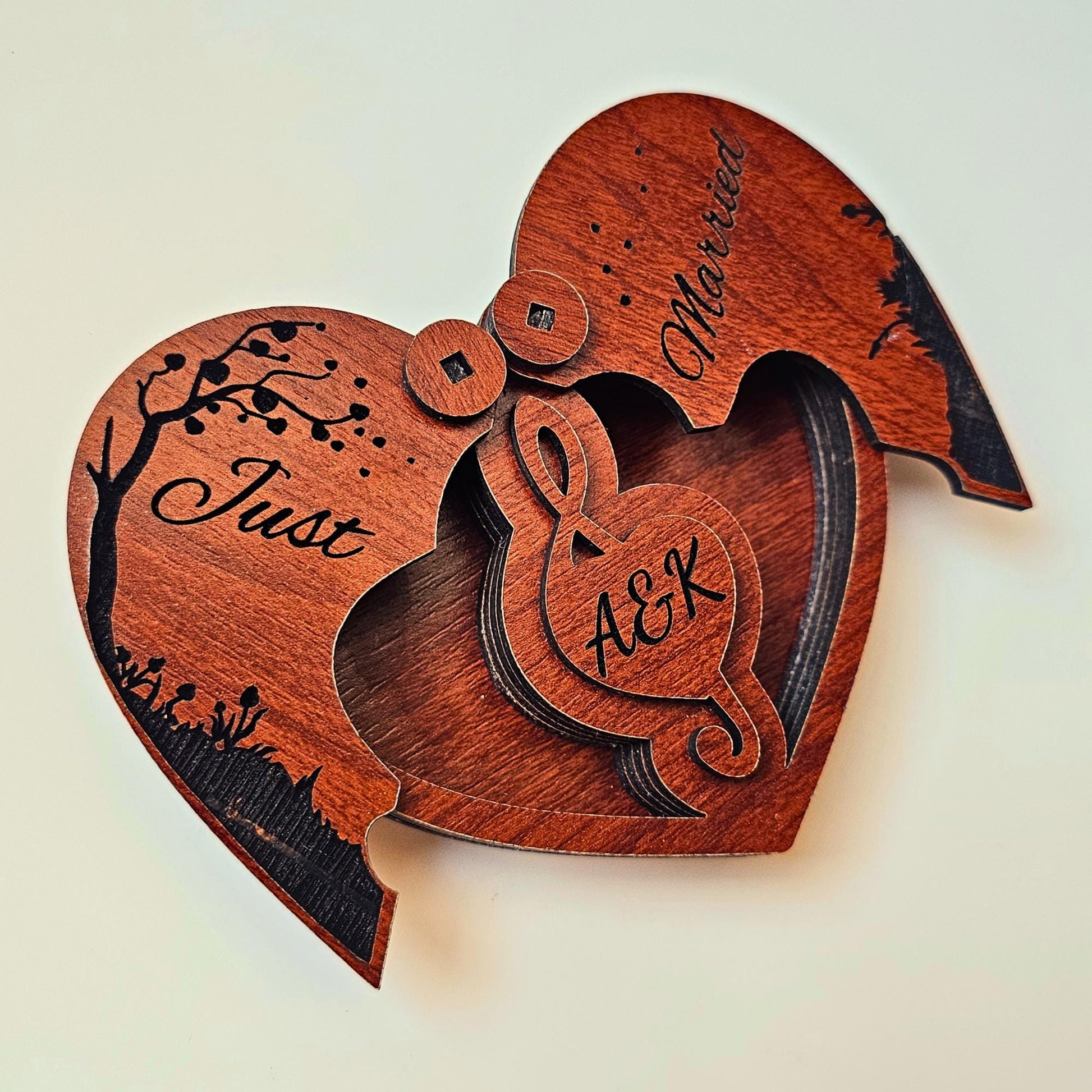 A heart-shaped wooden keepsake box engraved with “Love Story” and couple initials, used as a personalized engagement ring box, wedding proposal ring holder, or anniversary memory gift. This laser engraved wooden jewelry box for couples serves as a romantic keepsake or handmade custom box for storing wedding bands. Ideal for romantic events like Valentine's Day, wedding proposals, or surprise engagements.