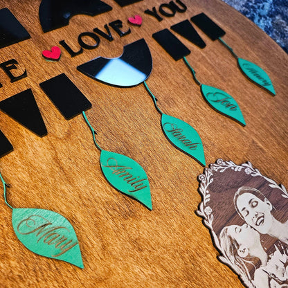 Close-up of black acrylic MOM text and green leaf name tags on brown oak wood – engraved photo below