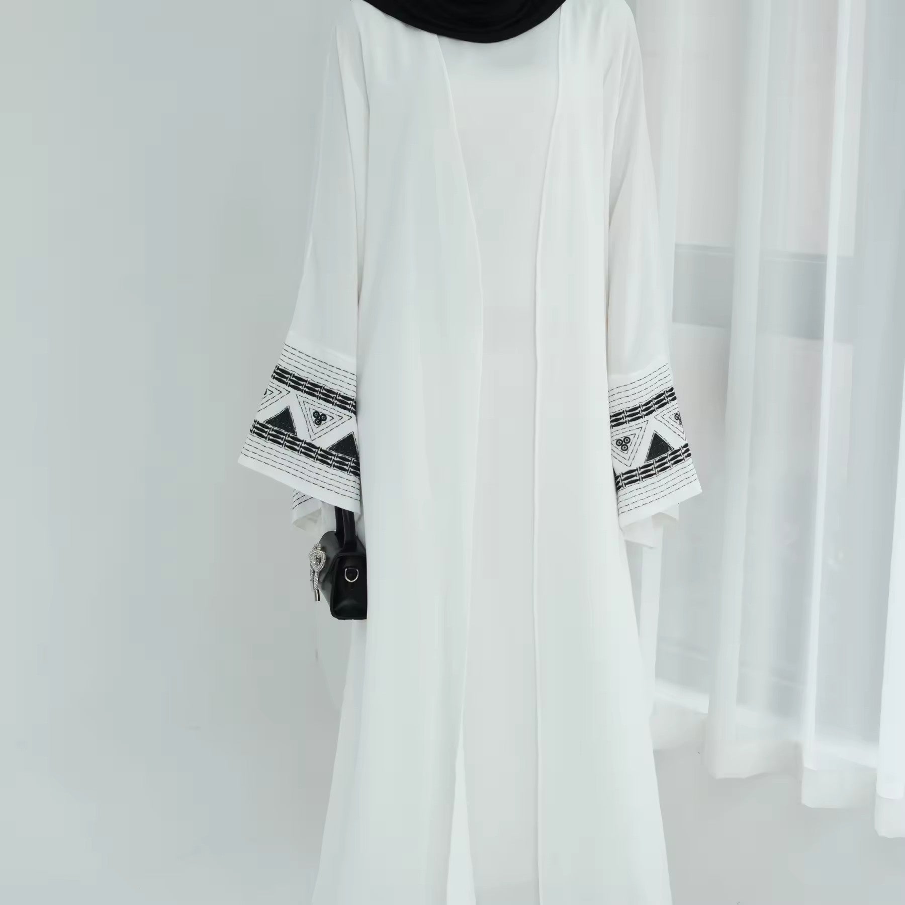Zoom on white abaya showing embroidered cuffs – elegant prayer dress
